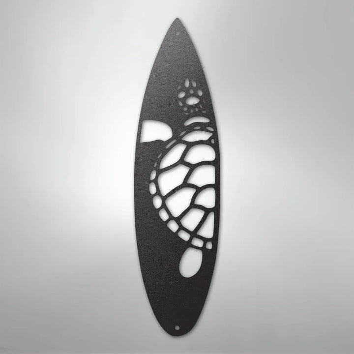 Black metal wall art shaped like a surfboard with a cut-out turtle design.