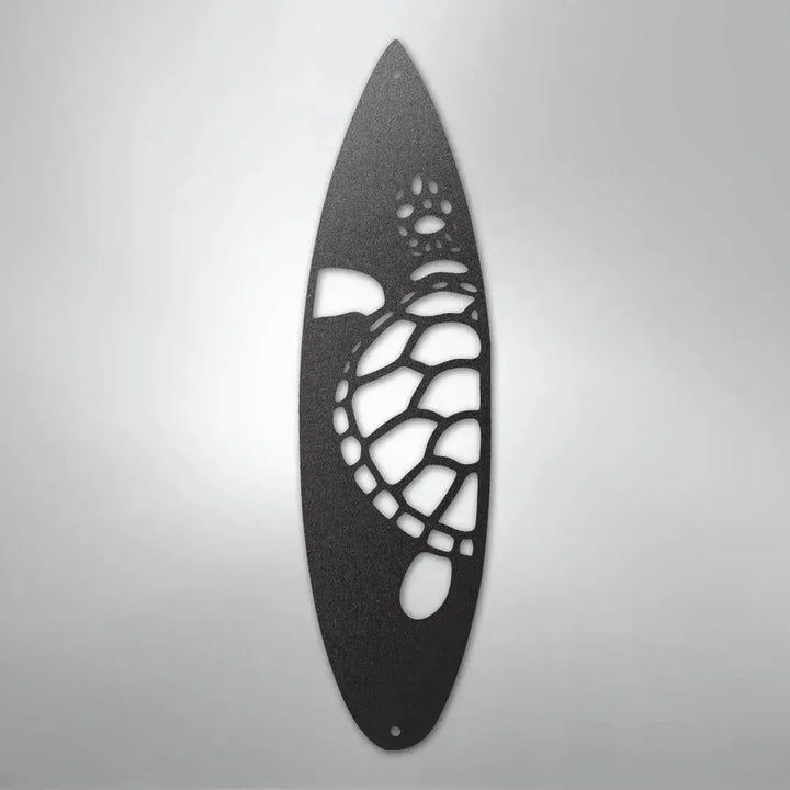 Black metal wall art shaped like a surfboard with a cut-out turtle design.