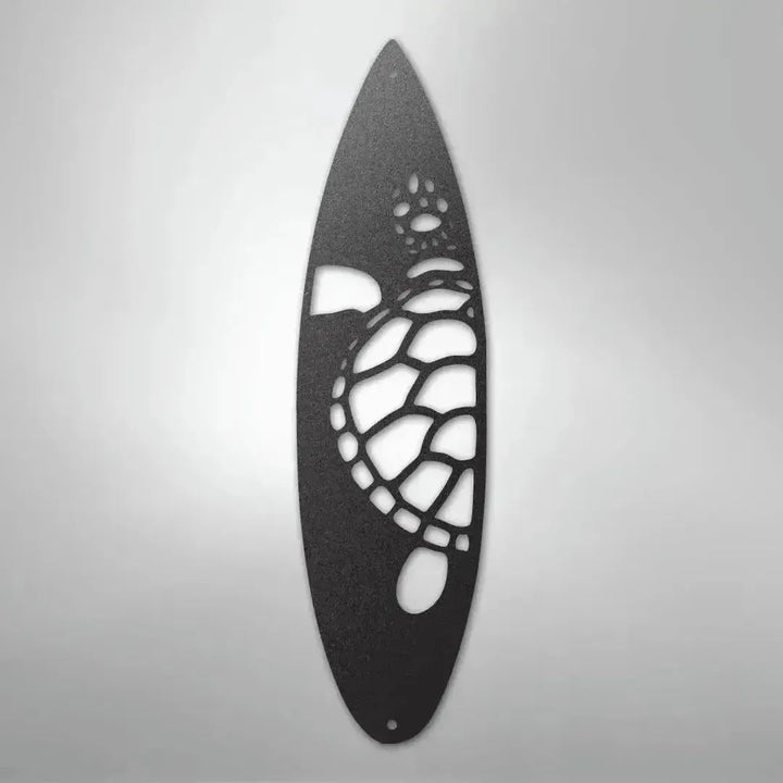 Black metal wall art shaped like a surfboard with a cut-out turtle design.