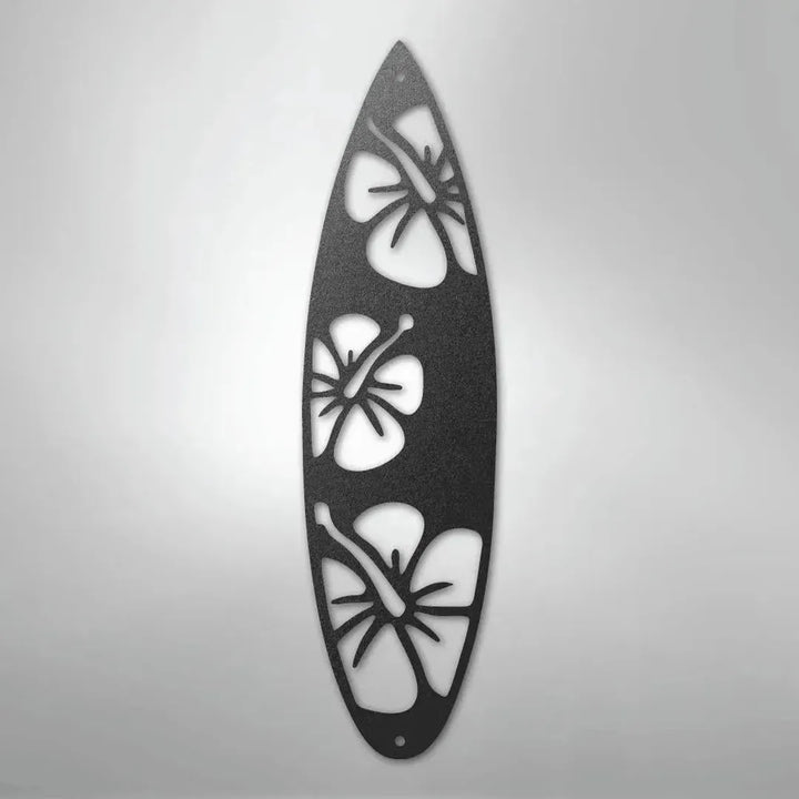 Black metal surfboard wall art with three hibiscus flower cutouts.