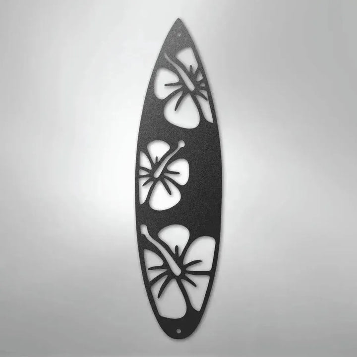 Black metal surfboard wall art with three hibiscus flower cutouts.