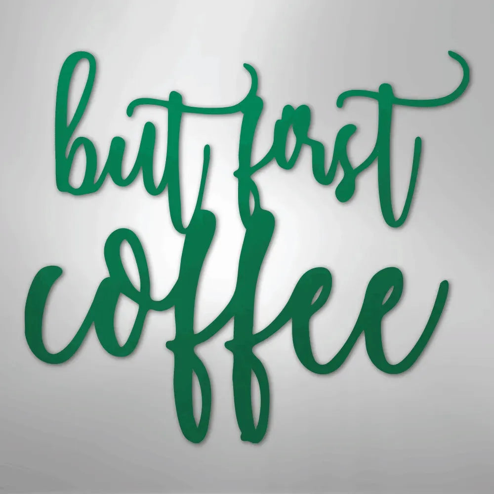 Green metal wall art with "but first coffee" in elegant script.
