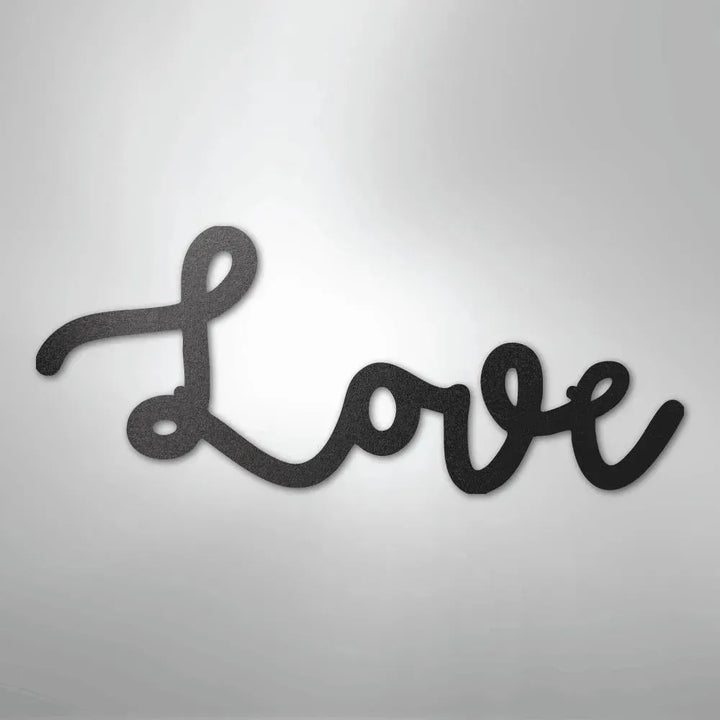 Black script "Love" metal wall art with a textured finish, casting a subtle shadow.