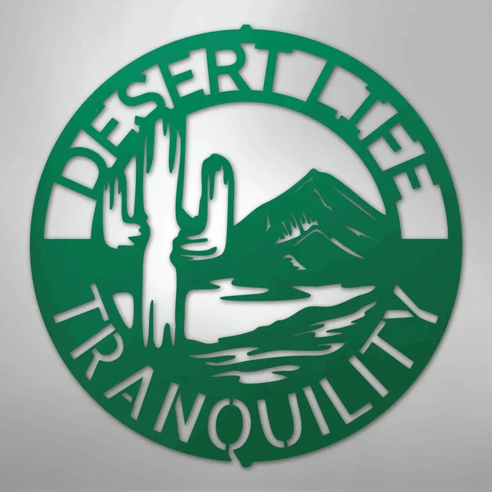 Green metal wall art: "Desert Life Tranquility" monogram with saguaro cactus, mountains, and water.