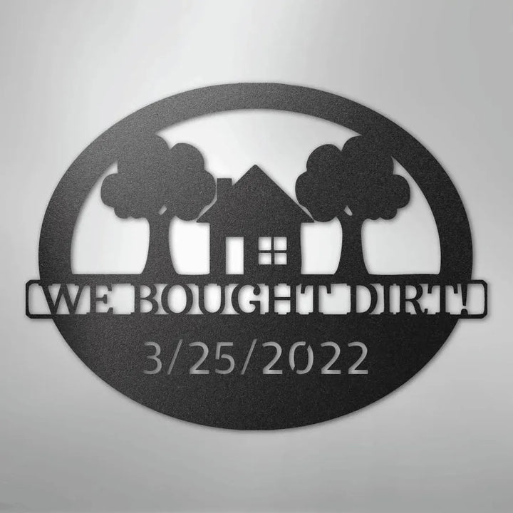 Black metal oval wall art with "WE BOUGHT DIRT!" and "3/25/2022" text, house, and trees.