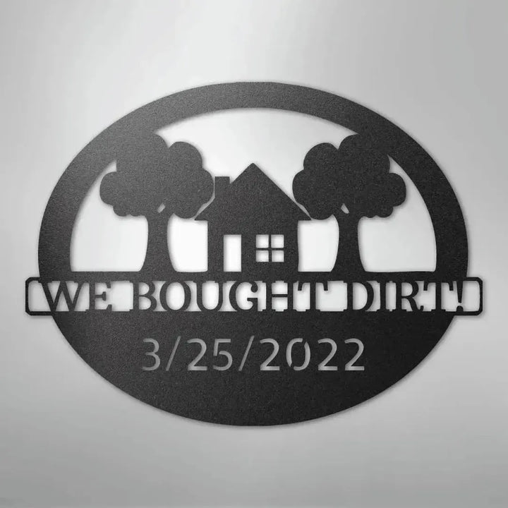 Black metal oval wall art with "WE BOUGHT DIRT!" and "3/25/2022" text, house, and trees.