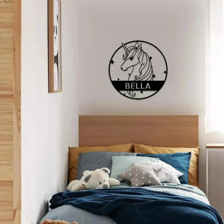 Black metal unicorn monogram wall art with "BELLA" in a child's bedroom.