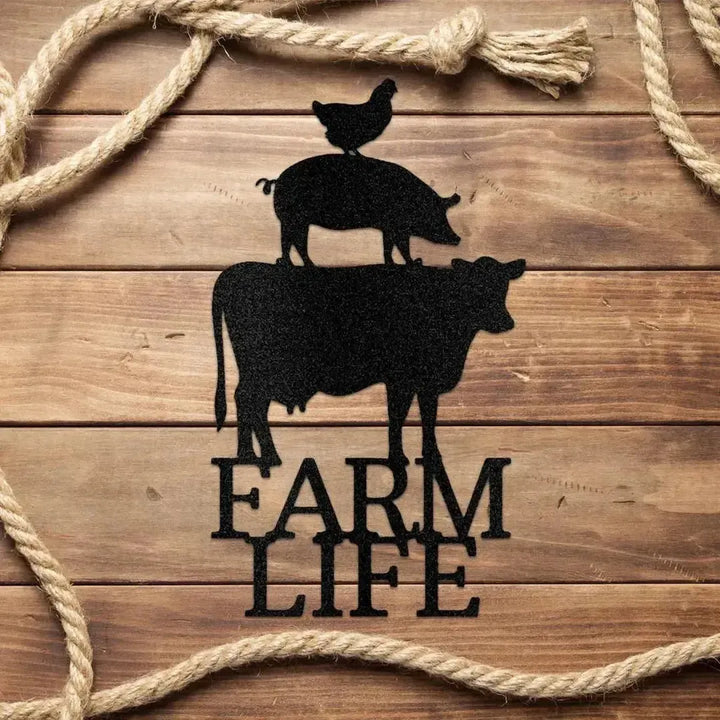 Black metal farm animal art: cow, pig, chicken stacked, with "FARM LIFE" text, on wood with rope.
