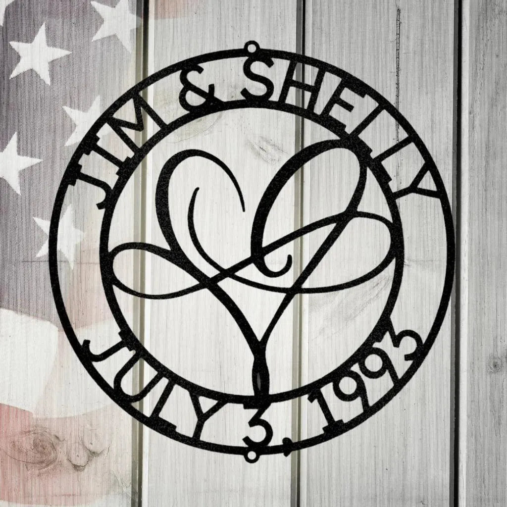 Black metal "Infinite Love Monogram" with names "Jim & Shelly" and date "July 3, 1993" encircling a heart design.