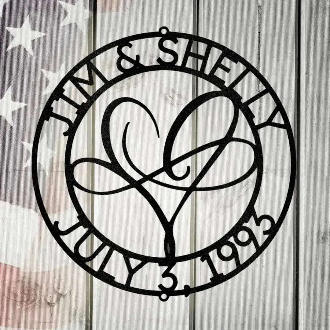Black metal "Infinite Love Monogram" with names "Jim & Shelly" and date "July 3, 1993" encircling a heart design.