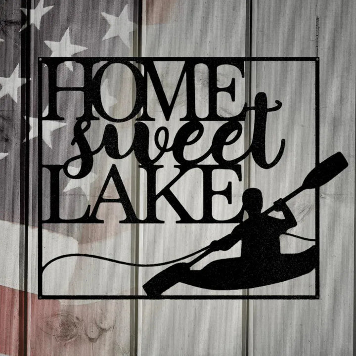 Black metal "HOME sweet LAKE" wall art with a kayaker silhouette, on a distressed American flag background.