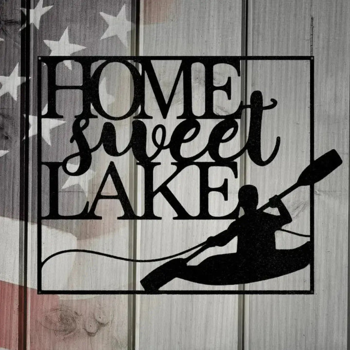 Black metal "HOME sweet LAKE" wall art with a kayaker silhouette, on a distressed American flag background.