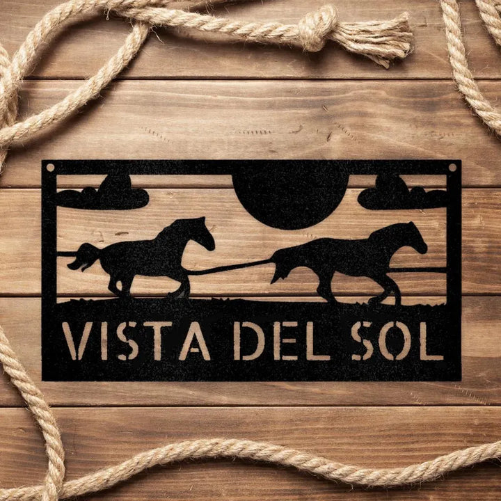 Black metal racing horses monogram sign with "VISTA DEL SOL" text on rustic wood.