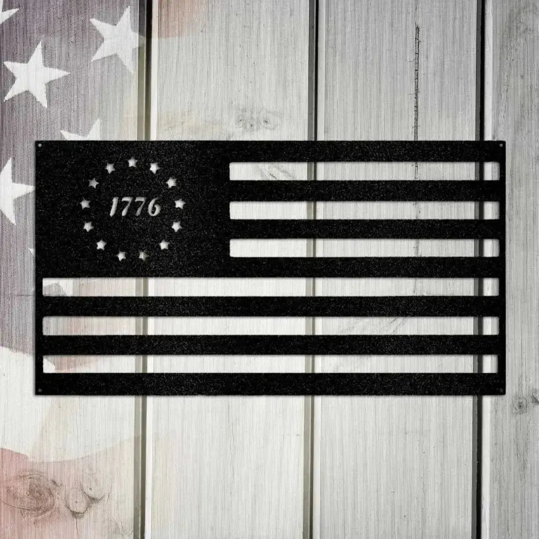 Black metal 1776 flag wall art with 13 stars in a circle, mounted on a rustic wooden background.