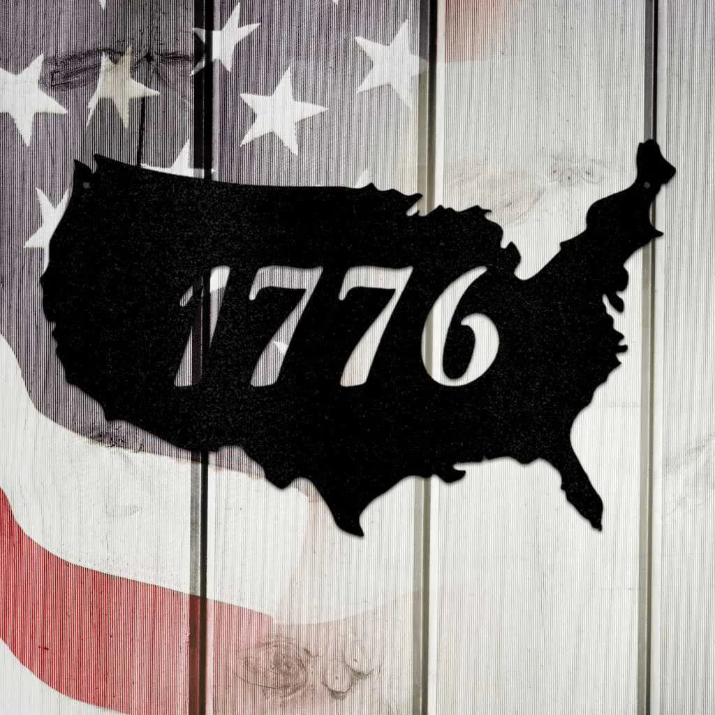 Black metal USA map wall art with "1776" cut out, set against a distressed American flag background.