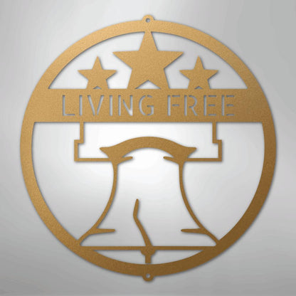 Gold metal wall art featuring a circular design with a Liberty Bell, three stars, and "LIVING FREE.