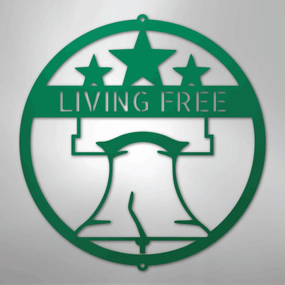 Green metal Liberty Bell monogram wall art with "LIVING FREE" text and three stars.