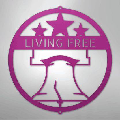 Pink metal Liberty Bell monogram wall art with "LIVING FREE" text and three stars.