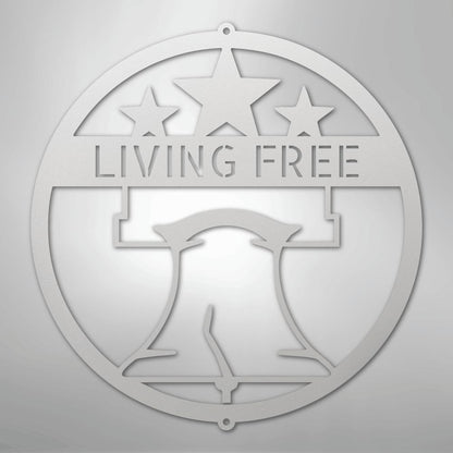 Silver metal wall art featuring a Liberty Bell, three stars, and "LIVING FREE" in a circular design.