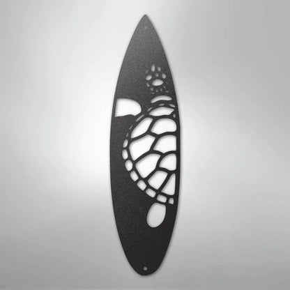 Black metal wall art shaped like a surfboard with a cut-out turtle design.