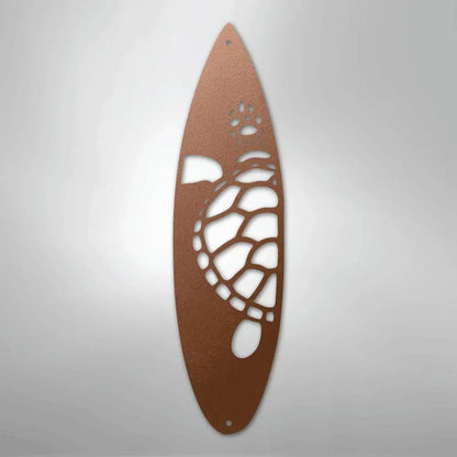 Copper metal wall art of a surfboard with a cut-out turtle design.