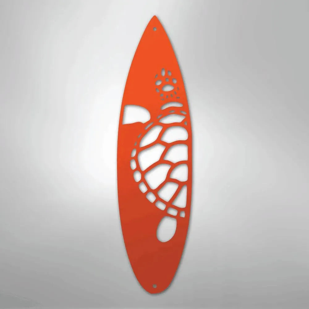 Orange metal wall art shaped like a surfboard with a cutout turtle design.
