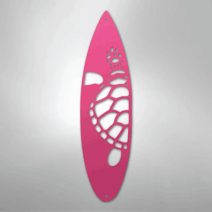 Pink metal surfboard wall art with a cutout turtle and paw prints.