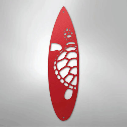 Red metal wall art shaped like a surfboard with a cutout turtle design.