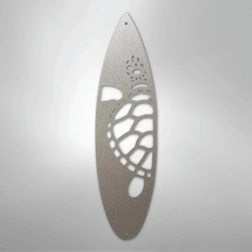 Silver metal surfboard wall art with a cutout turtle design.