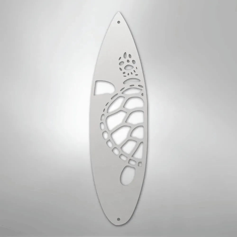 White metal surfboard wall art with a cutout turtle design.