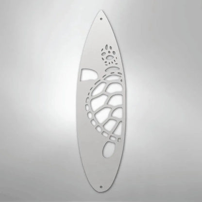 White metal surfboard wall art with a cutout turtle design.
