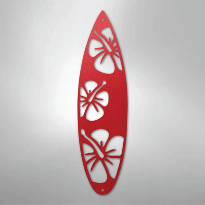 Red metal surfboard wall art with three hibiscus flower cutouts.