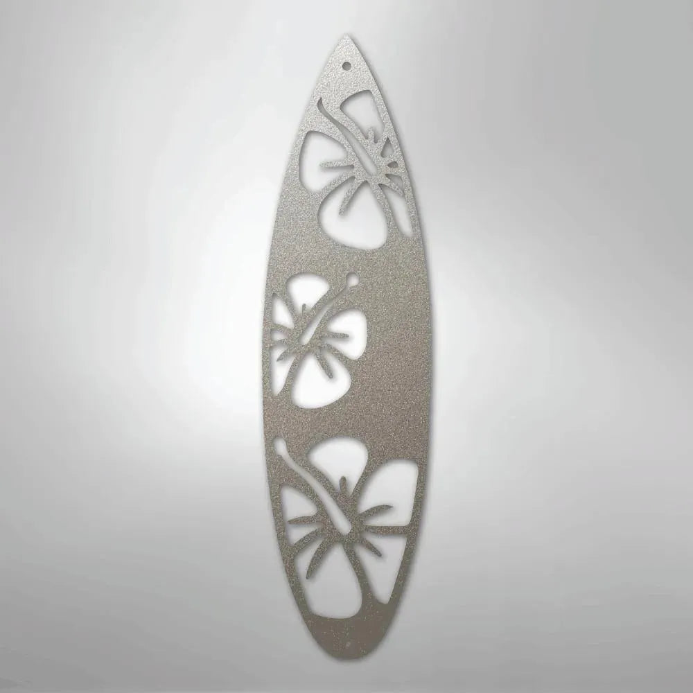 Silver metal surfboard wall art with three cutout hibiscus flowers.