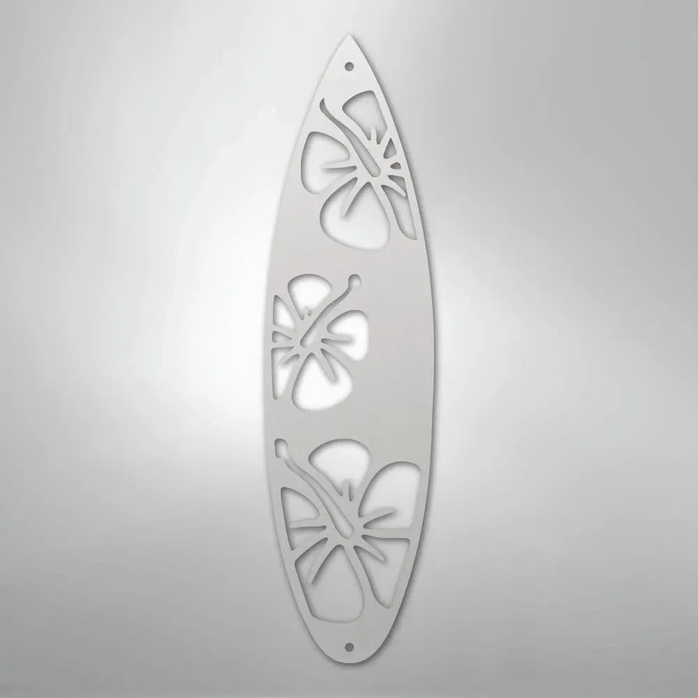 White metal surfboard wall art with three cutout hibiscus flower designs.