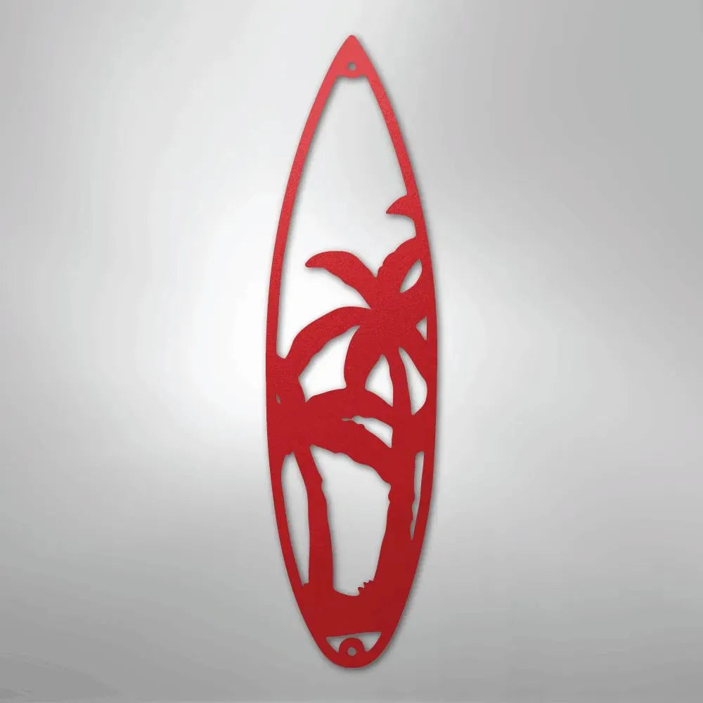 Red metal surfboard wall art with palm tree cutout design.