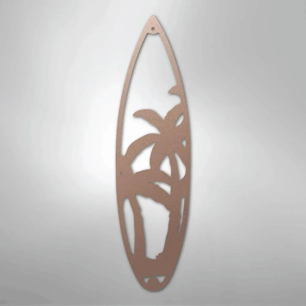 Rose gold metal surfboard wall art with palm tree cutout design.