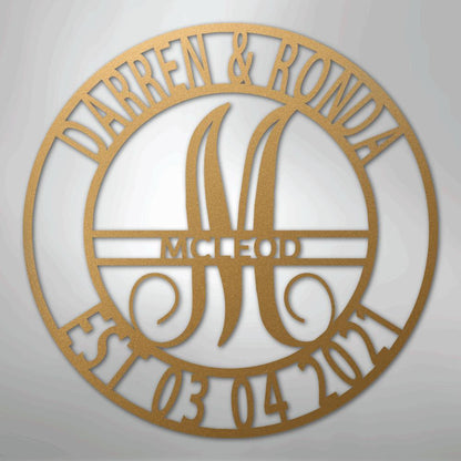 Gold metal family name wall art with "Darren & Ronda," a large "M," "McLeod," and "Est. 03 04 2021" in a circular design.