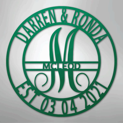 Green metal family name wall art with "Darren & Ronda," a large "M," "McLeod," and "Est 03 04 2021" in a circular design.