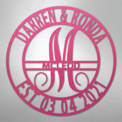 Pink metal family name wall art with "Darren & Ronda," a large "M," "McLeod," and "Est. 03 04 2021" in a circular design.