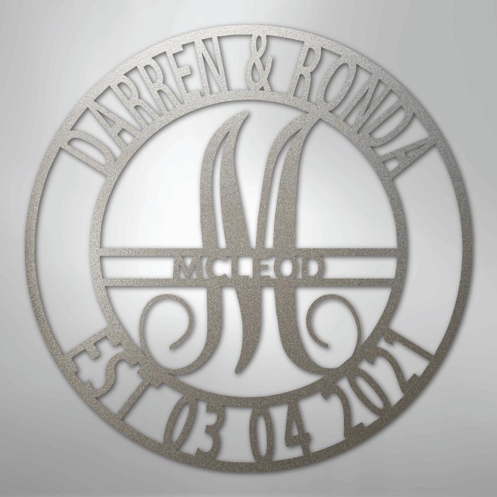 Round silver metal wall art with "DARREN & RONDA," a large "M," "MCLEOD," and "EST 03 04 2021" cut out.
