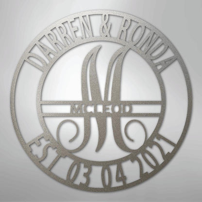 Round silver metal wall art with "DARREN & RONDA," a large "M," "MCLEOD," and "EST 03 04 2021" cut out.