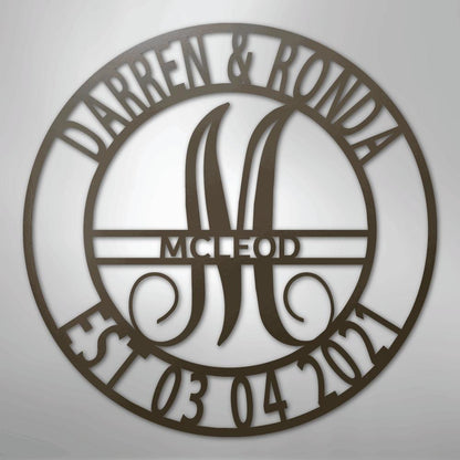 Round brown metal family name wall art with "Darren & Ronda," a large "M," "McLeod," and "Est 03 04 2021.