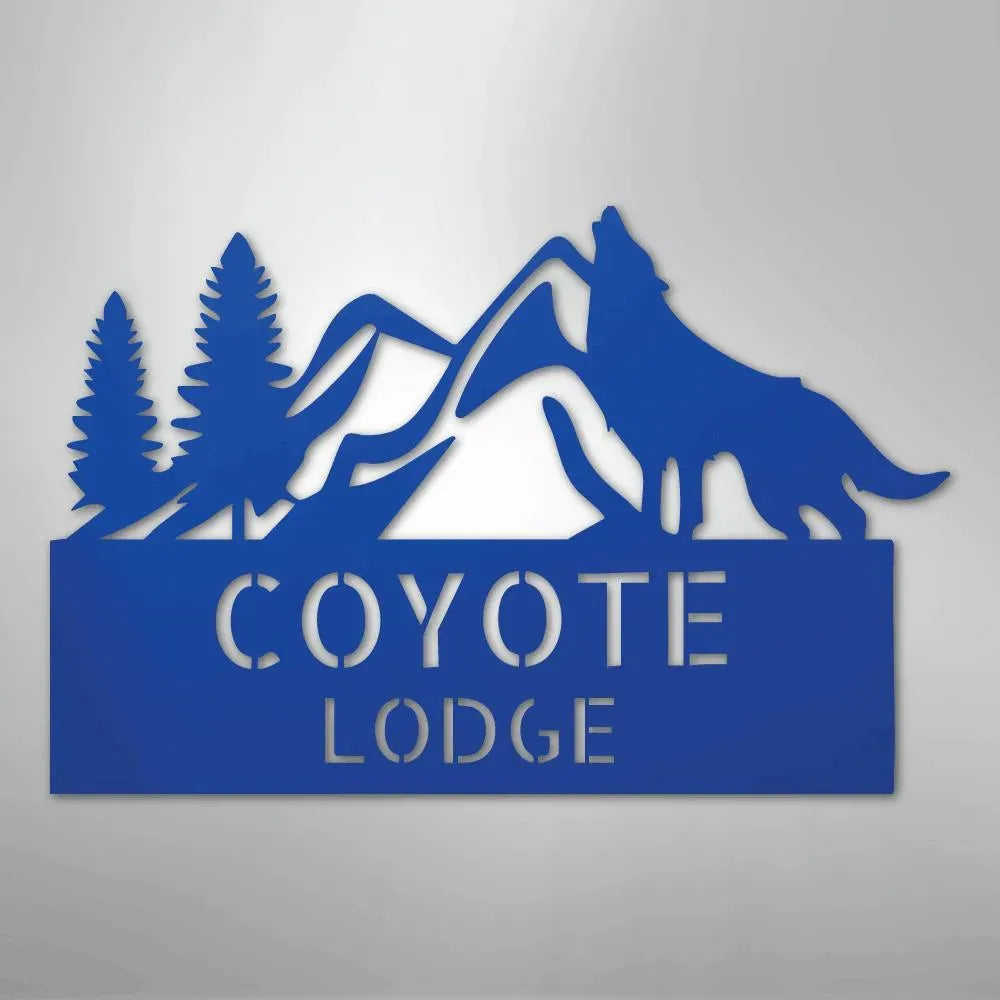 Blue metal wall art featuring mountains, pine trees, and a howling coyote above "COYOTE LODGE.