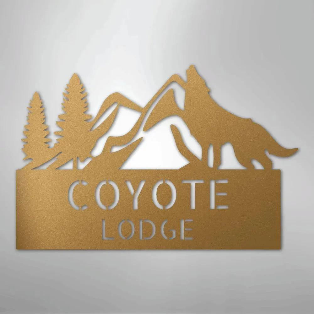 Bronze metal wall art featuring a howling coyote, pine trees, mountains, and "COYOTE LODGE" text.
