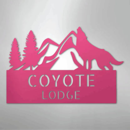 Pink metal wall art featuring mountains, pine trees, a howling wolf, and "COYOTE LODGE" text.