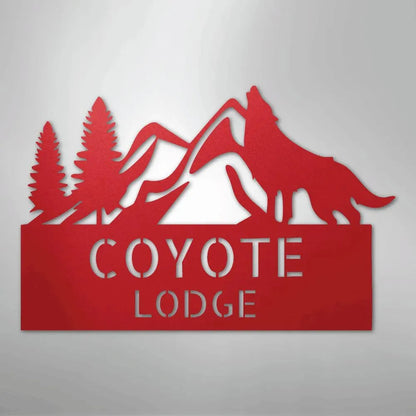 Red metal wall art featuring a howling coyote, mountains, pine trees, and "COYOTE LODGE" text.