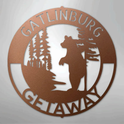 Copper metal wall art with a bear, pine trees, and "Gatlinburg Getaway" text in a circular design.