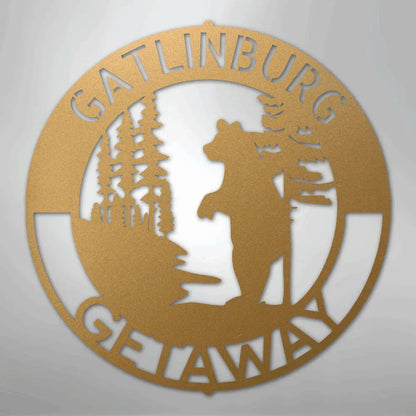 Gold metal wall art with a bear, trees, and "Gatlinburg Getaway" text in a circular design.