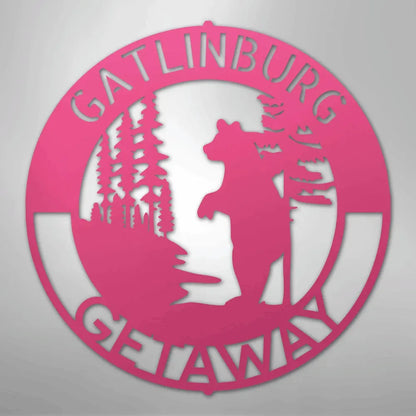Pink metal wall art with "Gatlinburg Getaway" text, bear, and pine trees.