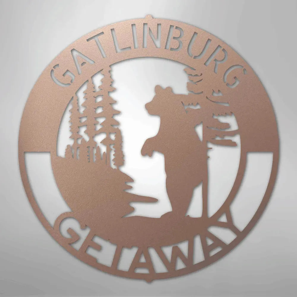 Copper metal wall art with "Gatlinburg Getaway" text, a bear, and pine trees.